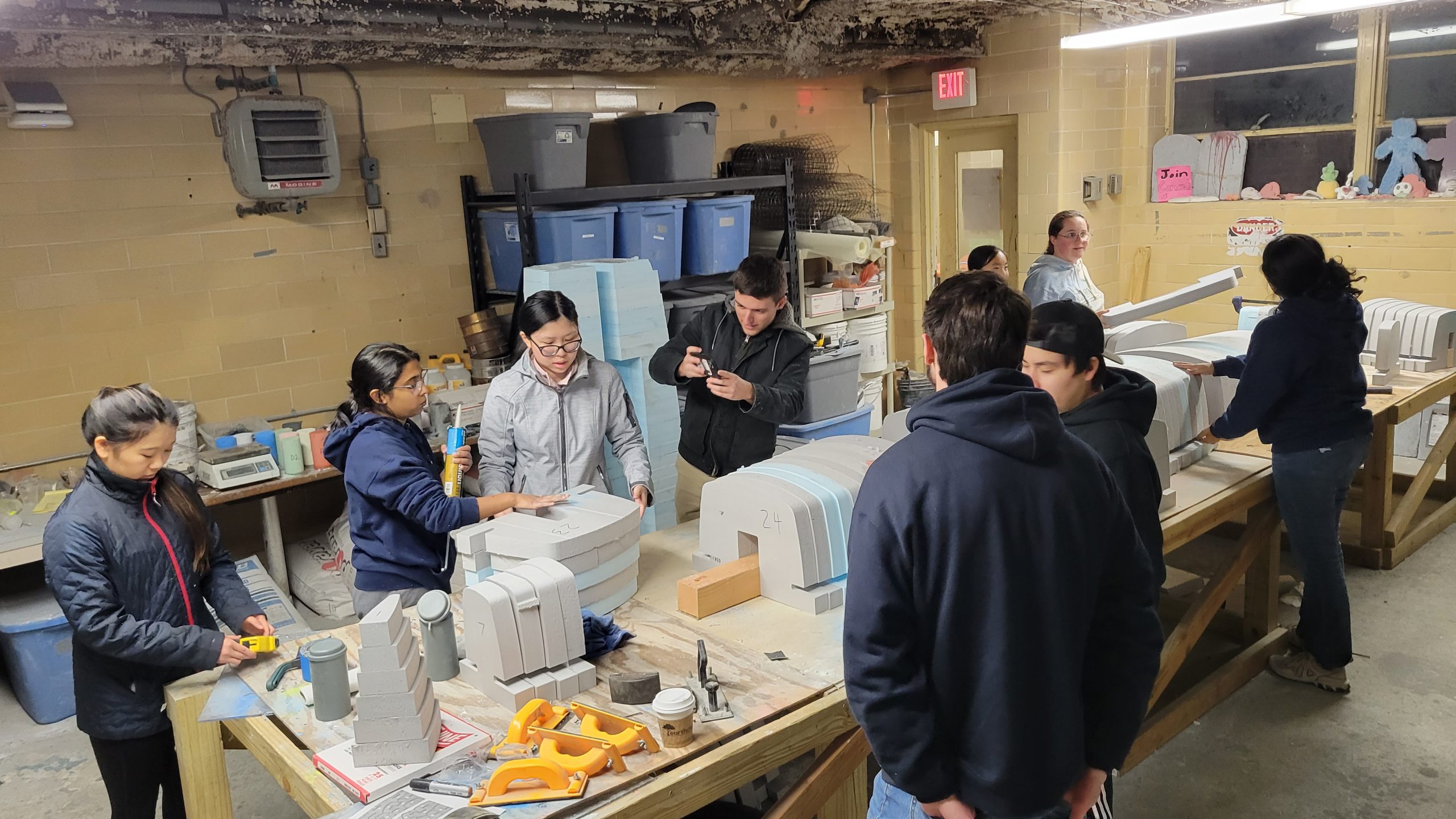 a group of members assembling the foam mold for the canoe