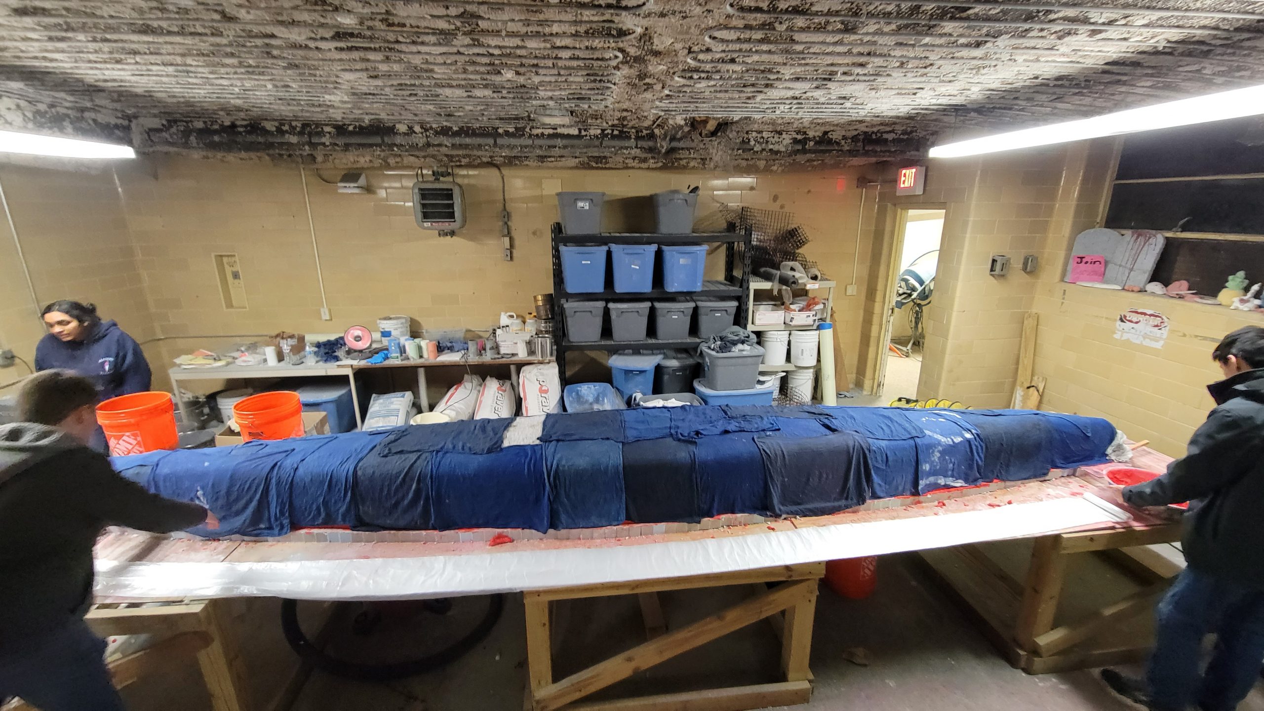 the finished canoe on a table and covered in wet rags to let cure